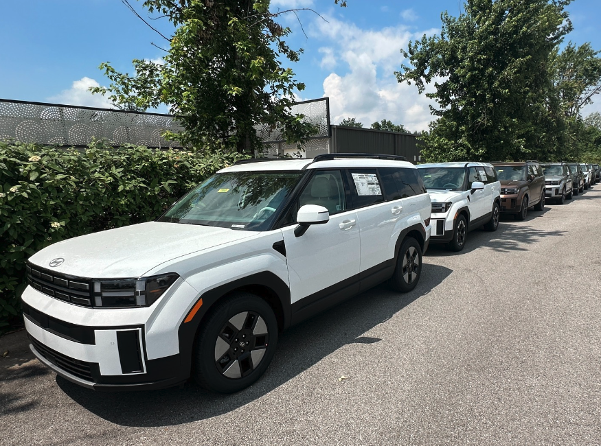 Row of new 2025 Hyundai SUVs parked outdoors, featuring white and earth-tone models with modern design and advanced features